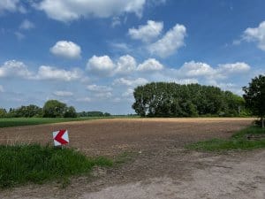 Abzweigung auf ländlichem Wirtschaftsweg nahe Hoya, umgeben von Feldern und Sommerwolken