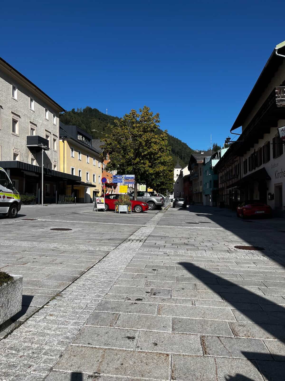 Historischer Marktplatz in St. Johann am Morgen, ruhige Gasse mit Häusern vor alpiner Bergkulisse