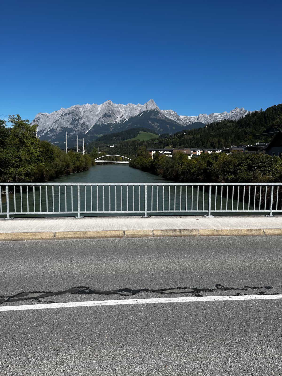 Türkisfarbener Alpenfluss mit Bäumen am Ufer, ruhige Natur entlang der Radroute