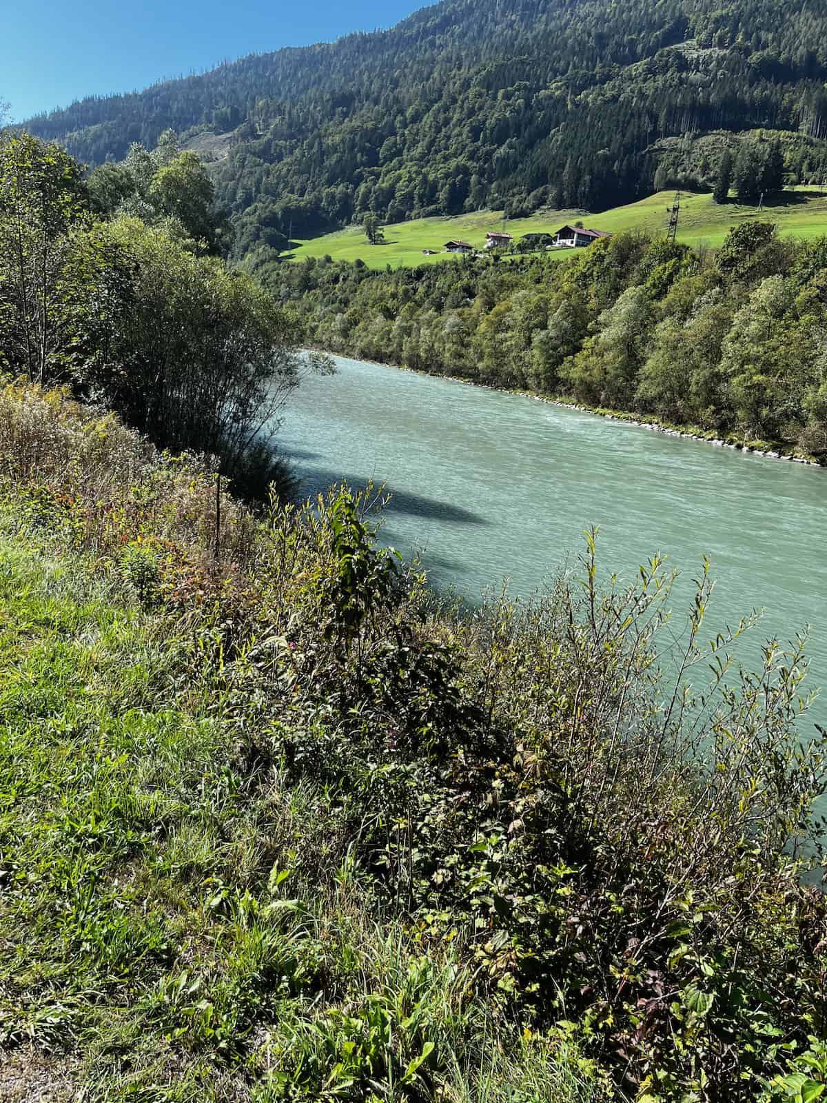 Selbstportrait eines Radreisenden mit voll bepacktem Fahrrad auf ruhiger Landstraße in den Bergen