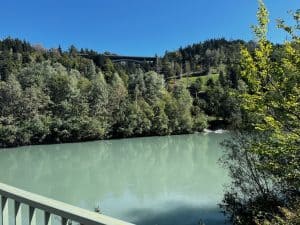 Radreisender vor alpiner Berglandschaft, kurzer Halt am Straßenrand mit Blick auf die Gipfel