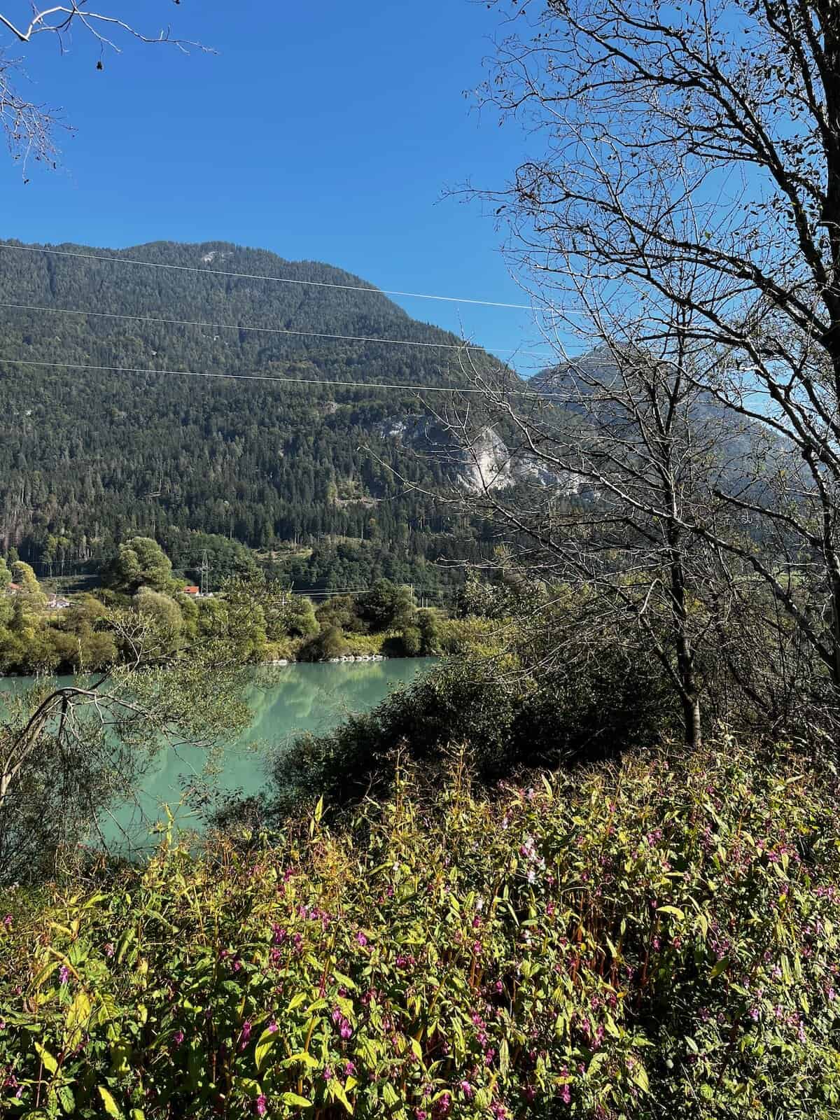Blick über die Drau auf bewaldete Hänge nahe Villach