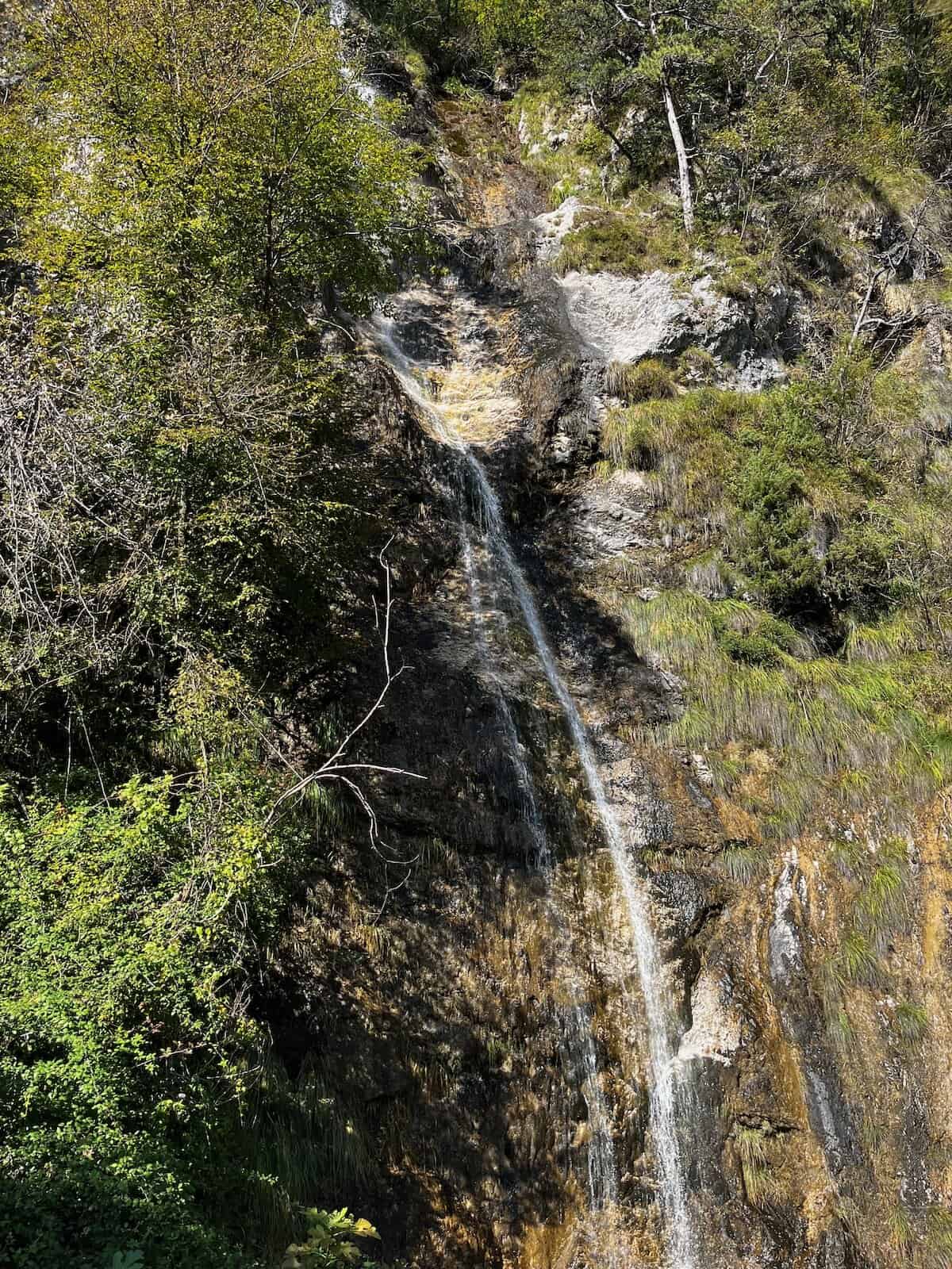 Schmaler Wasserfall im alpinen Waldgebiet, verstecktes Naturdetail entlang der Alpe-Adria-Tour