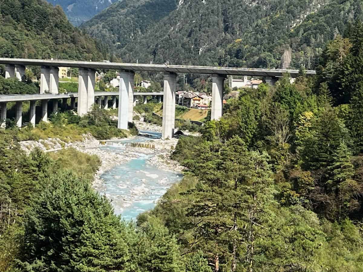 Hohe Brücke über türkisfarbenem Alpenfluss, technische Baukunst entlang der Alpe-Adria-Route
