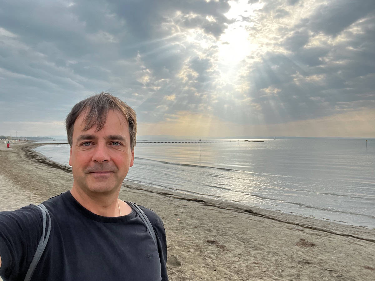 Radfahrer am Strand von Grado mit Meer im Hintergrund, Ziel der Alpe Adria Radreise