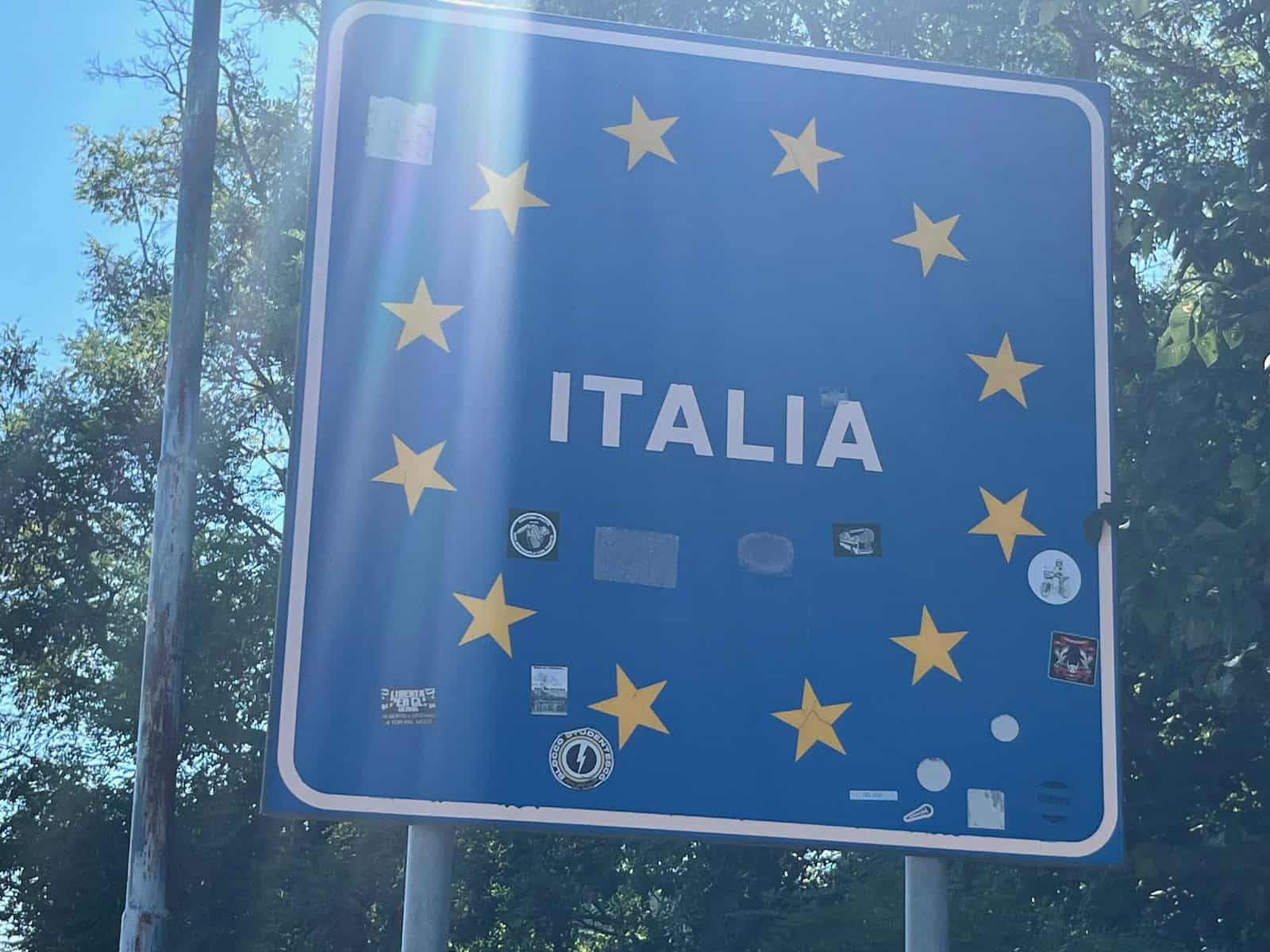 Radfahrer-Selfie am italienischen Grenzschild nach langer Bergetappe